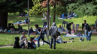 Purtret da fugitivs che giaschan u sesan en in parc a Como. 