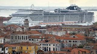 purtret d'ina nav giganta ch'è uschè gronda ch'ella surpassa ils tetgs da las chasas en citad. 