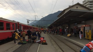 Persunas che arrivan a Glion cun tren cun tendas e gronda bagascha. 
