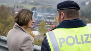 Ina dunna mira communabel cun in policists sur ils cunfins. 