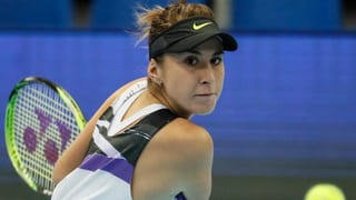 Purtret da Belinda Bencic focussada sin in bal da tennis. 