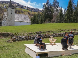 La culissa, pradas, mirs la tribuna e davos tir la baselgia da sontga Gada.