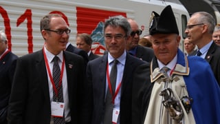 Christian Rathgeb e Mario Cavigelli vid ir a pe accumpagnads dal salter en cumplaina unifurma, davostiers ina locomotiva da las Viafiers federalas