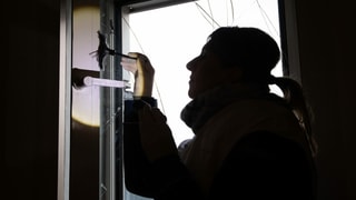 Purtret d'ina policista che piglia giu improntas da dets. 