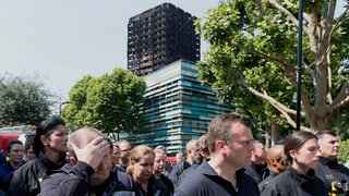 Purtret da pumpiers davant il Grenfell Tower. 