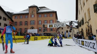 L'arriv da la Diagonela amez Zuoz, davos la chasa da scola oranscha, sur la lingia d'arriv in banner cun scrit si Zuoz, en l'arriv dus curriduras, ina giu per terra, davant in um che ha ses skis e bastuns en mauns.