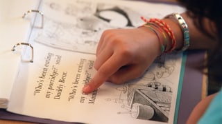 Scolara che legia in pitschen text englais. 