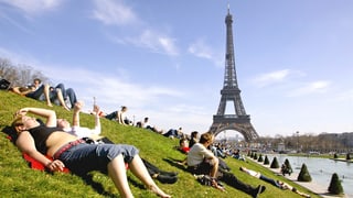 turists giaschan sin ina spunda, en il fund la tur Eiffel a Paris