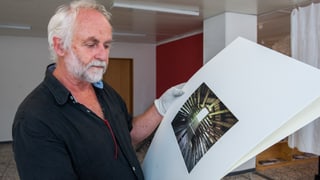 Fridolin Walcher vid preparar las fotografias per l'exposiziun a Glion.
