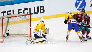 Giugaders da hockey miran sin il puck ch'è en il gol.
