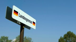 Il cunfin tranter la Svizra e la Germania a Constanza. Ins vesa ina tavla cun scrit si Landesgrenze e la bandiera da la Germania dad omaduas varts dal pled.