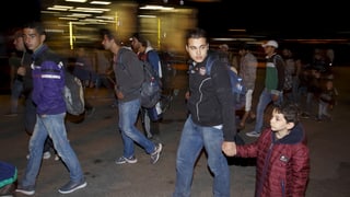 Fugitivs ch'arrivan al port d'Athen.