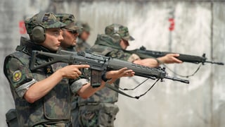 Purtret da militarists svizzers che sajettan cun armas. 