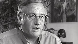 Portrait da Gian Meyer en alv e nair, in um enturn ils 60 cun egliers ed ina chamischa.