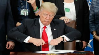 Donald Trump sesa vid ina maisa e suttascriva in decret per construir in mir al cunfin cun il Mexico.