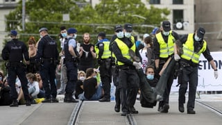 Purtret da policists che portan davent ils demonstrants e las demonstrantas. 