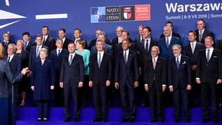 La uschenumnada fotografia da famiglia cun si ils partecipants pli impurtants gruppats enturn Obama.