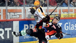 2 giugaders da hockey en in duell.