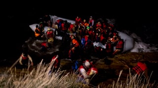 Ina bartga da fugitivs va a riva en la mar Egeica