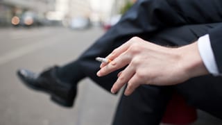 Purtret d'in um cun ina cigaretta enta maun. 