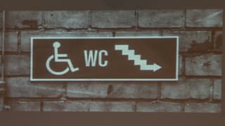 Placat cun sutga da rodas e l'inscripziun WC ed ina stgala. 
