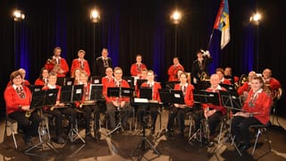 Die Societed da musica Cinuos-chel/Brail sitzend, mit roten Sennenchuteli