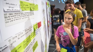 Greta Thunberg avant ina paraid cun chavazzins e cedels. Greta Thunberg avant ina paraid cun chavazzins e cedels.