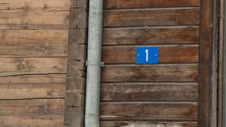 Ina tabla cun la numera da la chasa. 