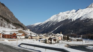 Vista sin S-chanf l'enviern, davant la via che fa ina cura, davos il vitg enramà da las muntagnas.