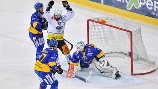 trais giugaders ed in goli da hockey en acziun