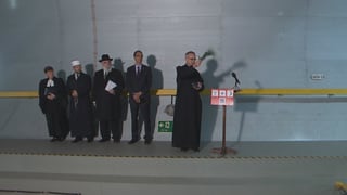 Tschintg sacerdots da las grondas religiuns e confessiuns en svizra benedeschan il tunnel dal Gottard. Els stattan en ritscha davon ina paraid.