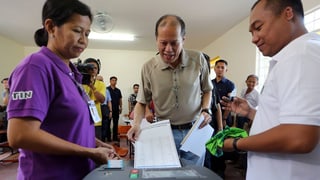 il president actual Benigno Aquino pren encunter la glista d'elecziun en in local d'eleger.