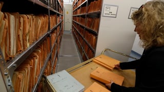 Archiv da la Stasi a Berlin, curuna cun bleras actas ed ina collavuratura mira tras quellas.