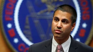 Ajit Pai avant l'emblem da l'autoritad