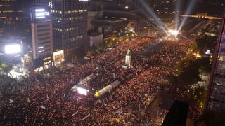 Purtret da la citad da Seoul e da la raspada da persunas che han demonstrà.