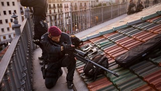 In policist catalan prepara sia arma sin in tetg en il center da Barcelona.