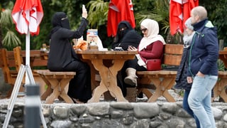 Dunnas muslimas sesan en in café ad Interlaken. 