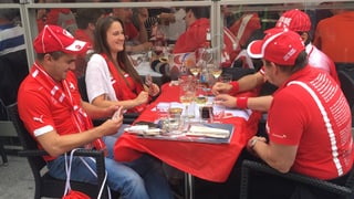 Quatter fans svizzers sesan sin terrassa d'in restaurant a Lille e dattan jass