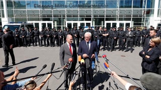 Els dus discurran avant ils policists.