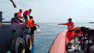 Las autoritads da salvament recupereschan tocca da l'aviun disgrazià ord la mar.