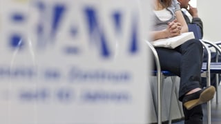 Purtret d'ina dunna che sesa sin ina sutga. Davantvart èsi si ina tabla dal RAV.