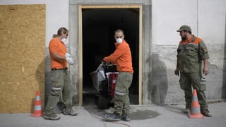 Commembers da la protecziun civila rumeschan ina chasa suenter la bova da Bondo.