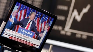 Ina televisiun cun Trump davos ina curs da la bursa. 