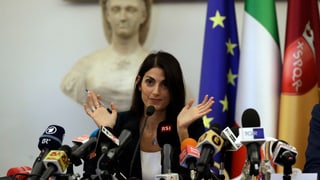 Purtret da Raggi durant ina conferenza da pressa. 