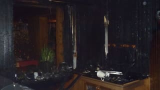 Stanza cun maisas e paraids nairas suenter il brischament en il hotel Bellavista a Ftan.