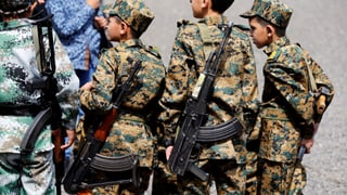 Purtret d'uffants cun en resti militaric e cun armas sin dies. 