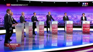 7 politichers da la Frantscha sin ina tribuna en in studio da televisiun