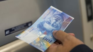 Um che retira 100 francs dad in bancomat.