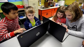 Quatter scolars stattan dus e dus davant dus computers ch'èn plazzads sin maisa