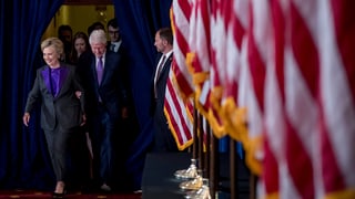 Hillary Clinton e ses um avant bleras bandieras. 